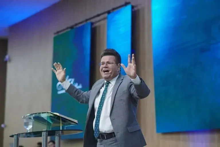 Jacques Balbino durante ministração em culto, com mãos erguidas no púlpito. (Foto: Reprodução)